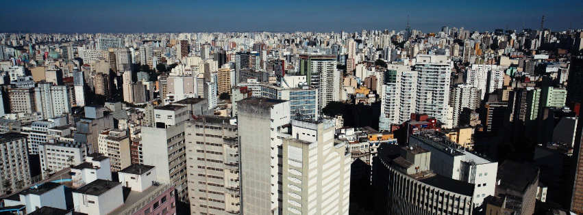 An aerial view of a city with lots of buildings and a blue sky.