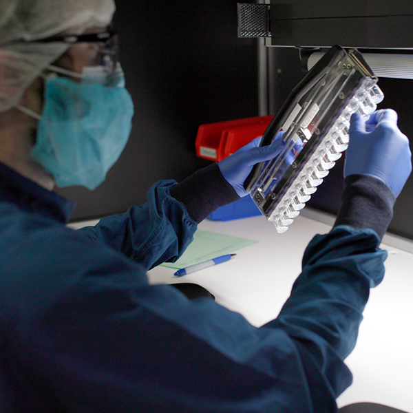 Remote post-production A person wearing a mask and gloves is working on a device