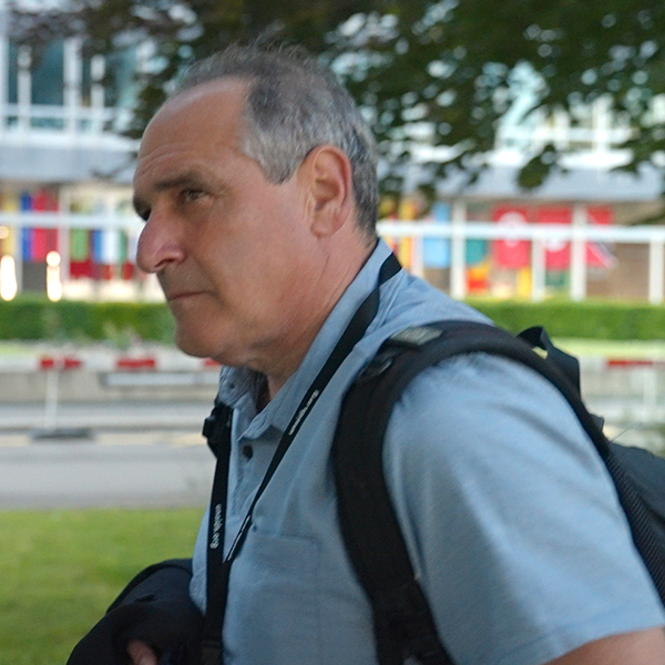 Remote post-production A man wearing a lanyard that says ' nikon ' on it