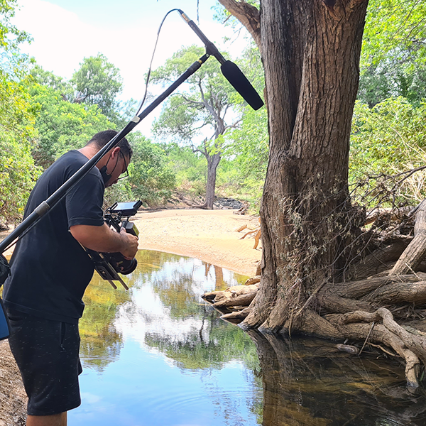 A man is taking a picture of a river with a camera.