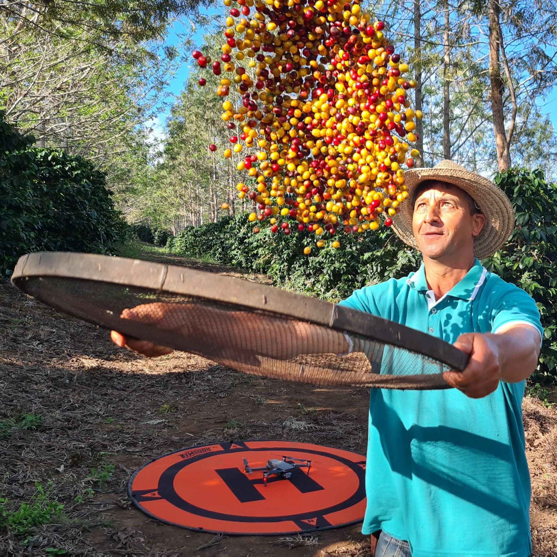A man in a hat is holding a wooden hoop in front of a helicopter.
