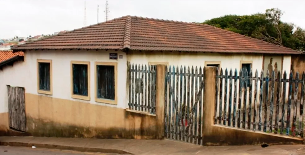 An old house with a fence around it and a tiled roof.
