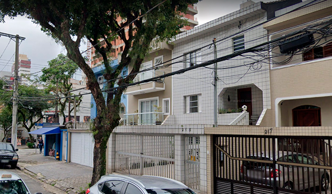A row of houses with cars parked in front of them.