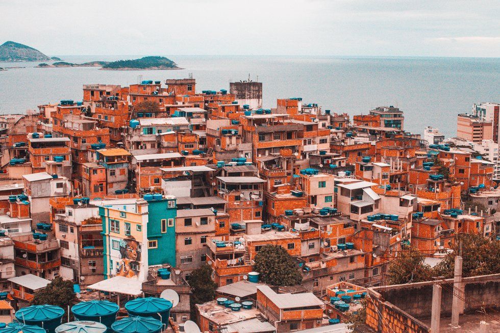 An aerial view of a slum area next to the ocean.