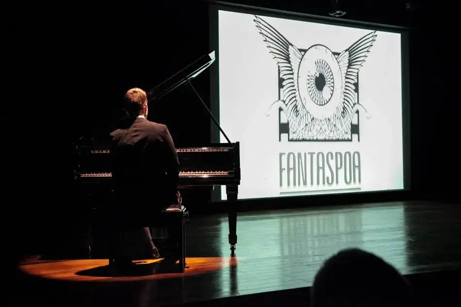 Im Vordergrund spielt ein Pianist, im Hintergrund läuft auf einer Leinwand der Film