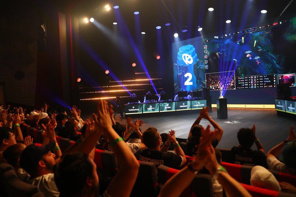 A crowd of people applauding in front of a stage with the number 2 on it