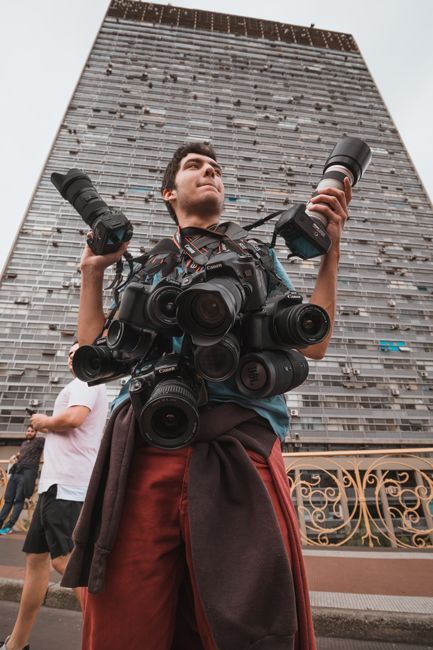 A photograher stands in a street of the city of São Paulo