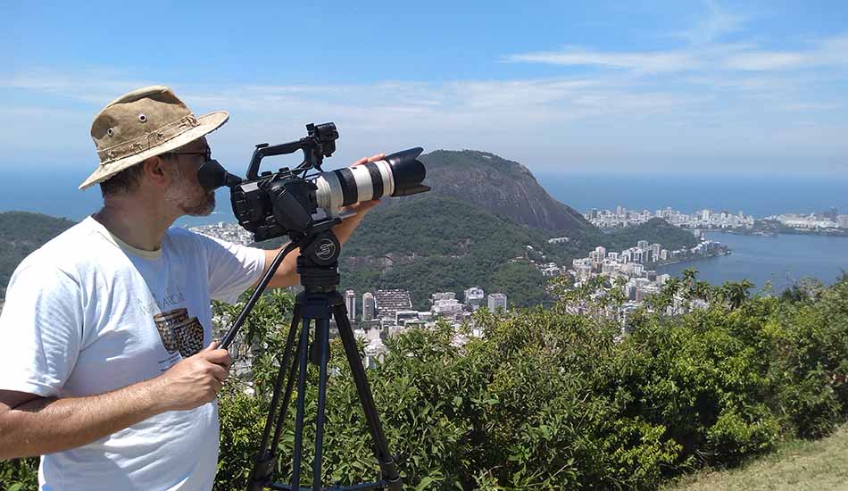 A man is taking a picture with a camera on a tripod.