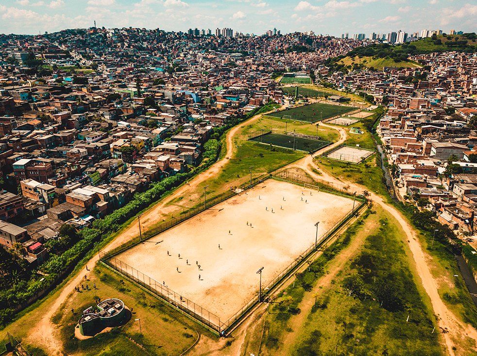 An aerial view of a soccer field, in the background Cidade Pedreira.
