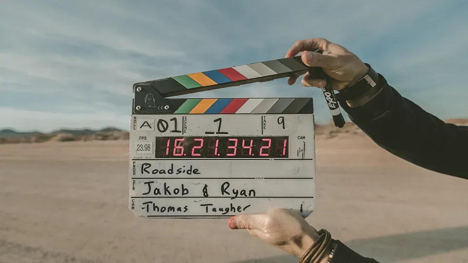 A person is holding a clapper board in their hand.