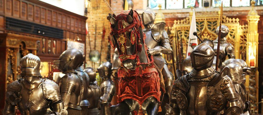 Des armures pour les humains et des protections pour un cheval, avec des lances et des étendards.