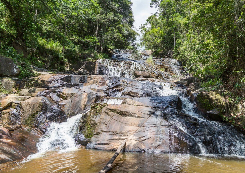 Une vue sur la cascade Palmeira, avec des roches sombres brillantes et de l'eau en cours d'exécution