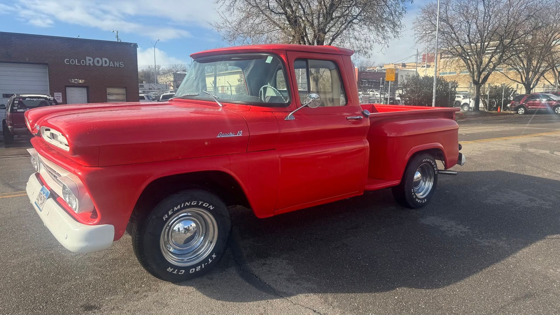 Bright red vintage pickup truck parked outdoors on a sunny day