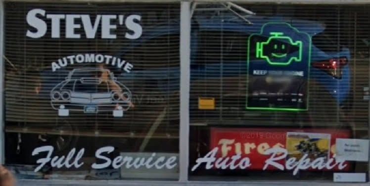 Steve’s Automotive storefront with “Full Service” and “Fire Auto Repair” signs and a neon engine light sign