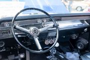 Classic car dashboard with chrome steering wheel, radio, and gauges in a bright interior