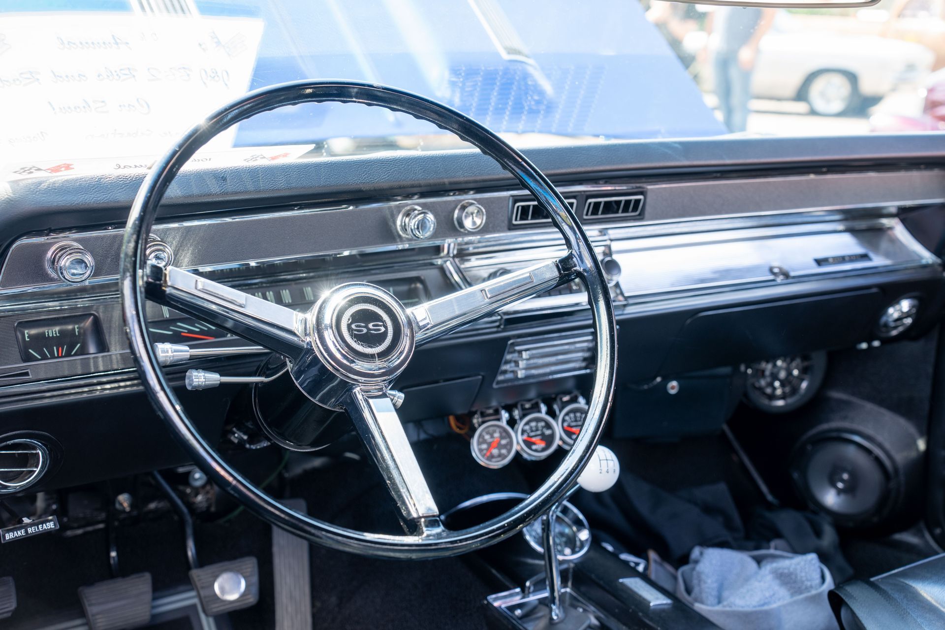 Classic car dashboard with chrome steering wheel, radio, and gauges in a bright interior