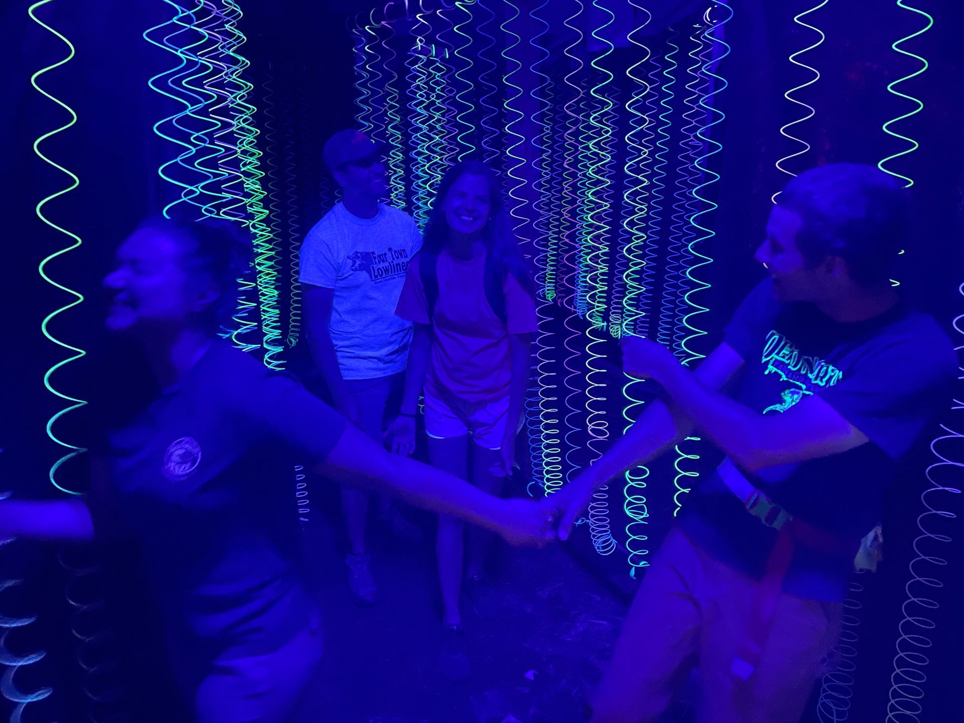 People laughing in the indoor blacklight Maze at the Great Vermont Corn Maze