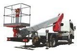 Piattaforma aerea montata su camion con braccio esteso. Camion bianco, componenti di sollevamento rossi, cestello con operatore.