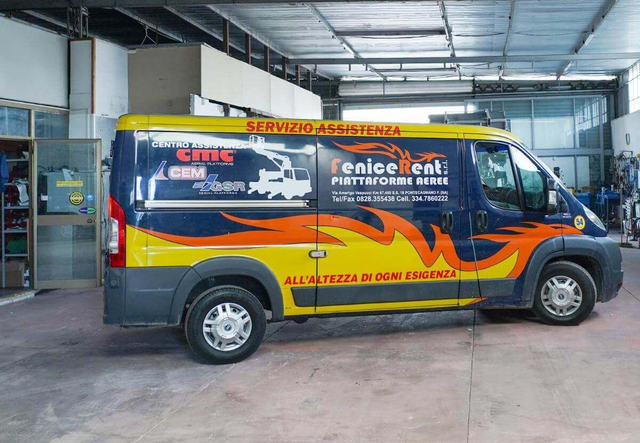 Furgone di servizio giallo e blu con logo parcheggiato in un garage.