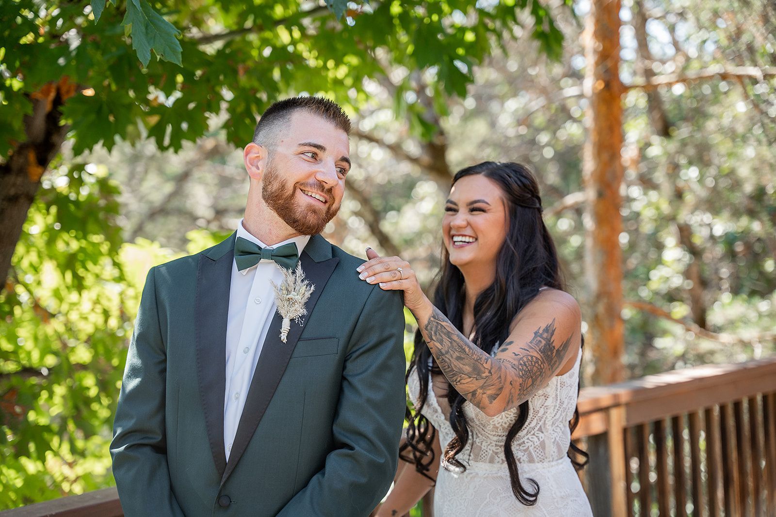 A bride and groom are standing next to each other on a deck.