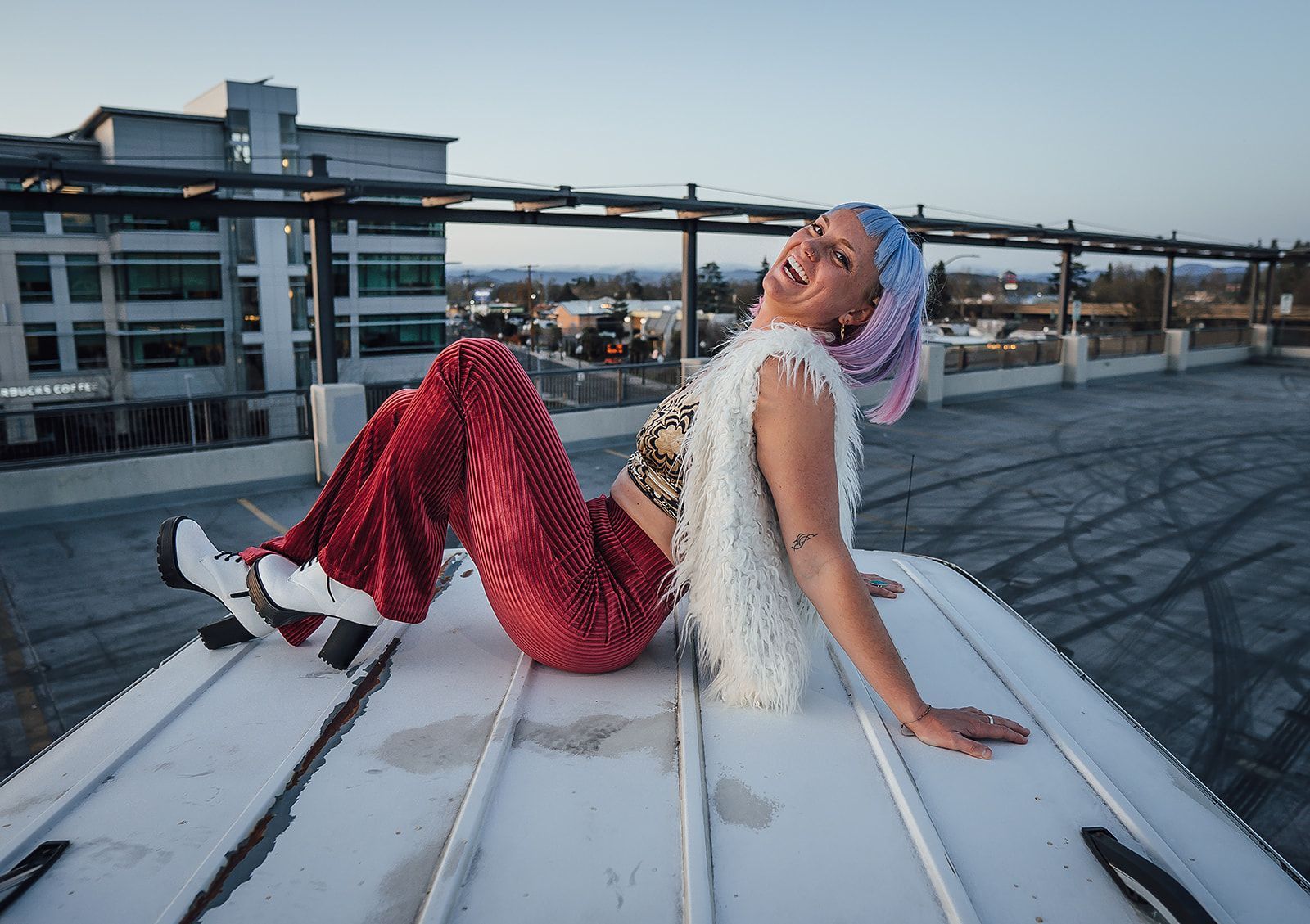 A woman is sitting on the roof of a building.