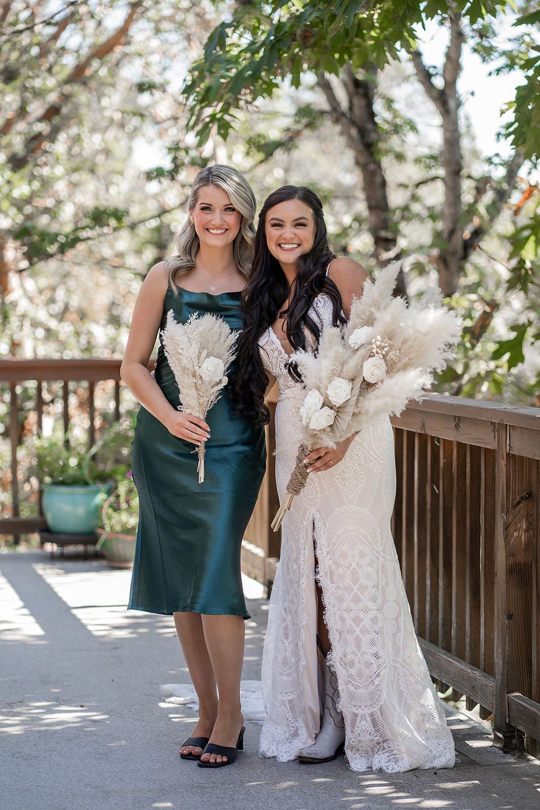 A bride and her bridesmaid are posing for a picture on a balcony.
