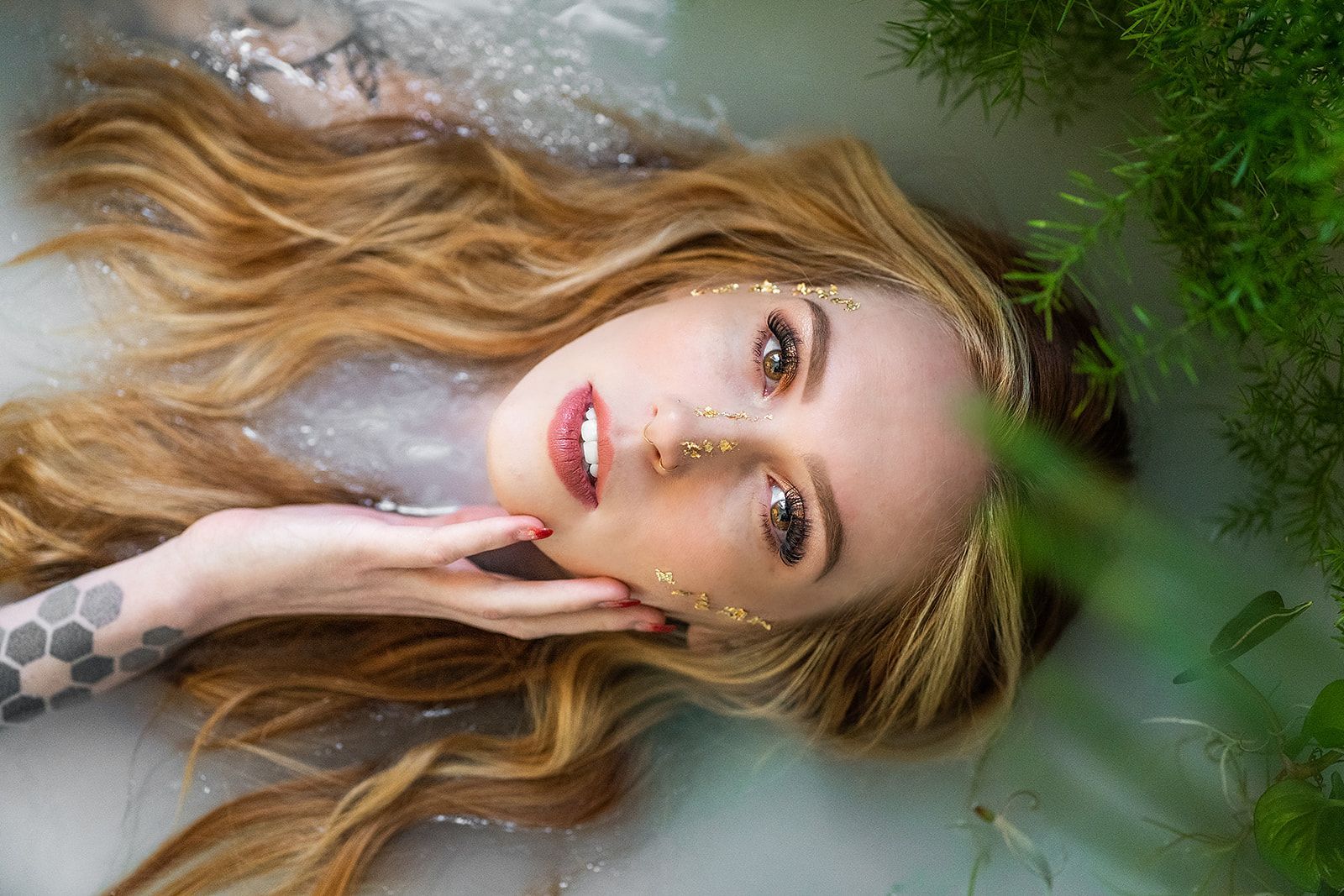 A woman is laying in a bathtub with her head in the water.