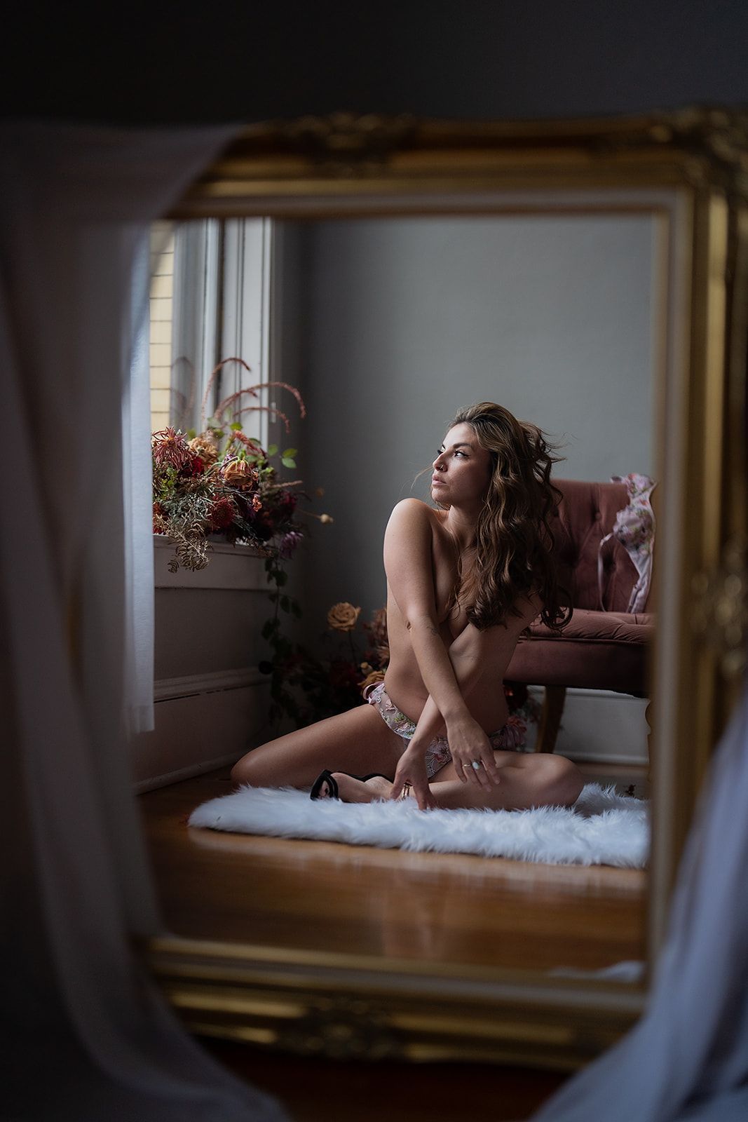 A woman poses on the floor for a boudoir photo shoot in Medford Oregon.