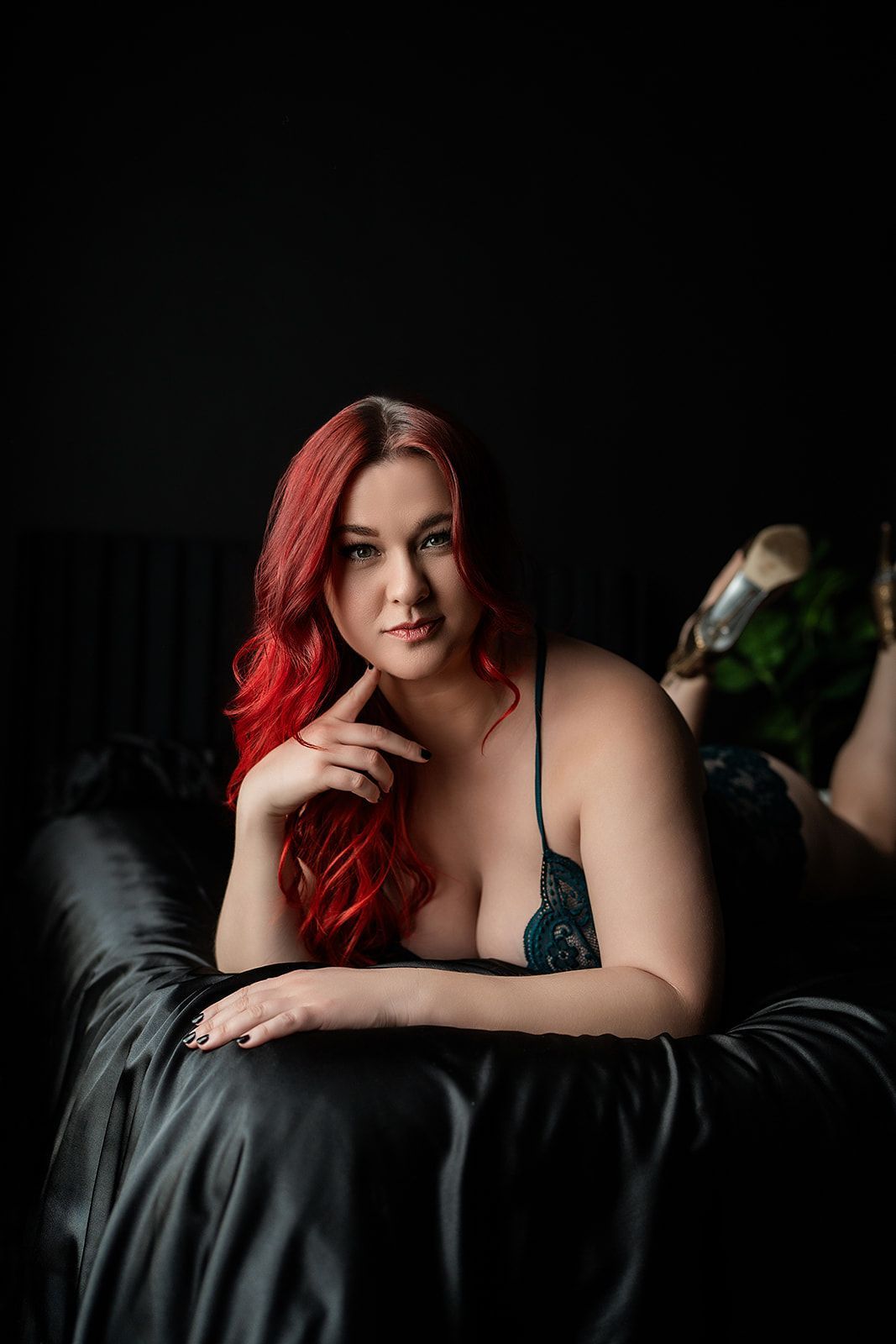 A woman with red hair is laying on a bed.