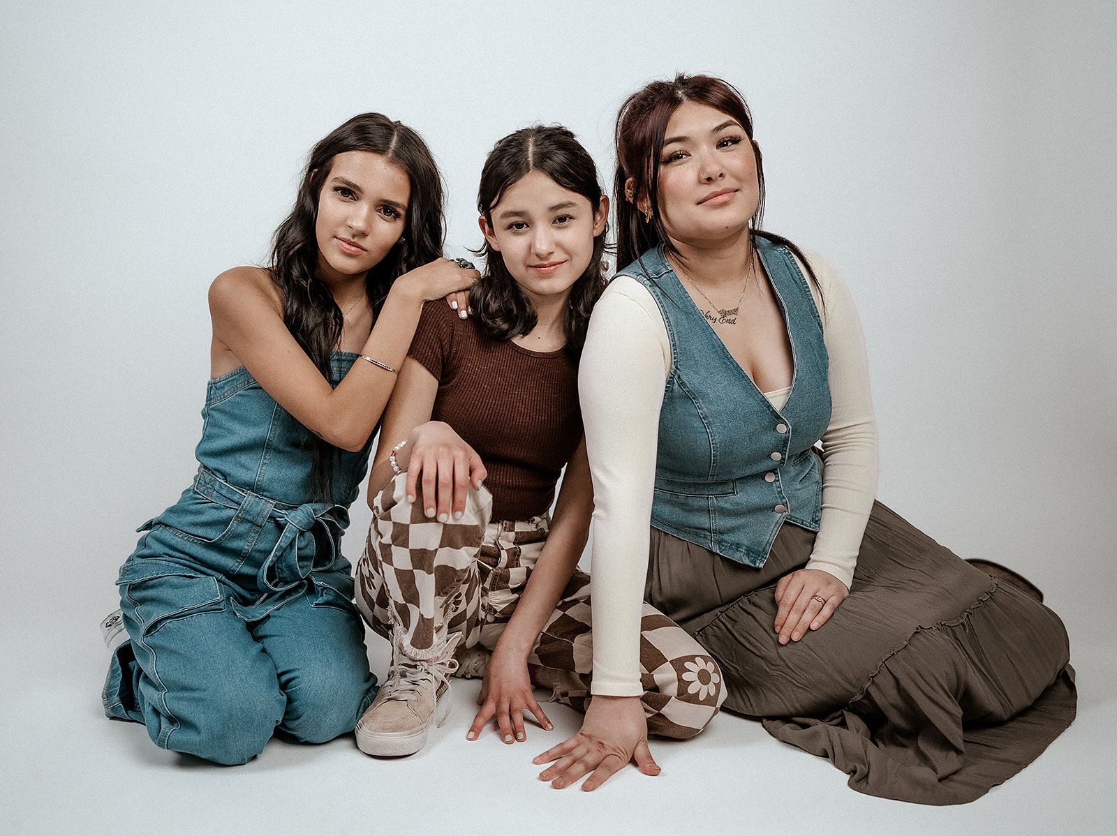 Three women are sitting next to each other on the floor.
