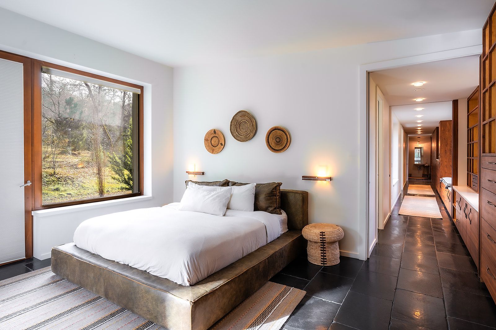 A bedroom with a large bed and a large window.