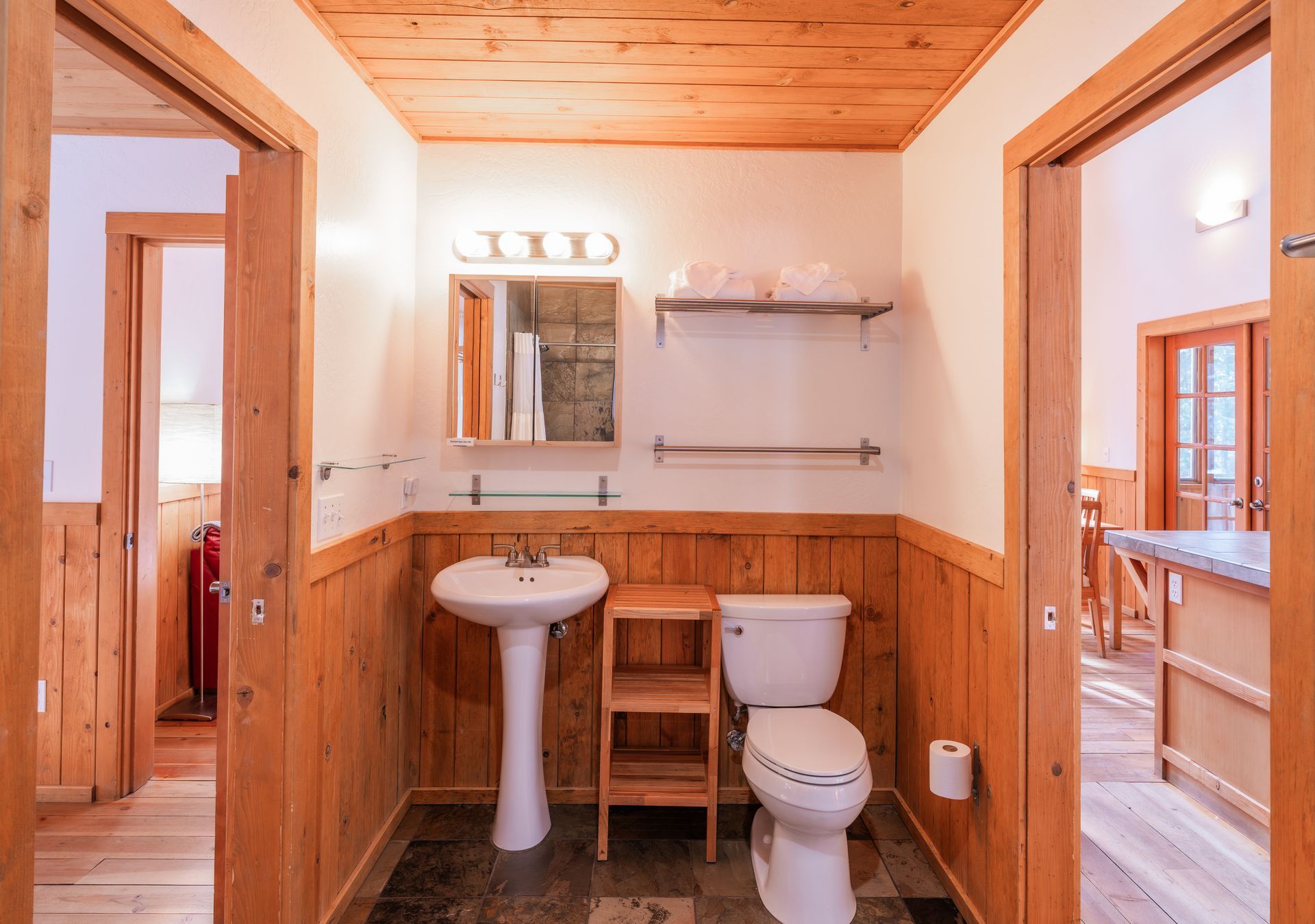 A bathroom with a toilet , sink and mirror.