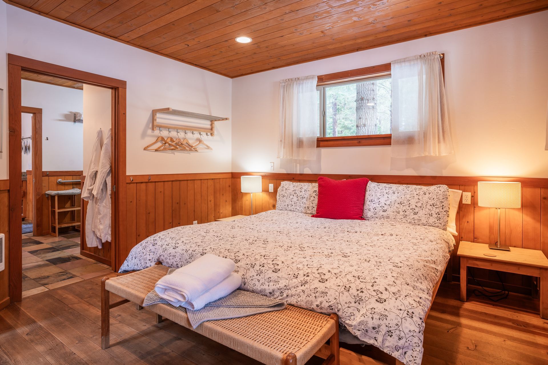A bedroom with a king size bed and a bench.