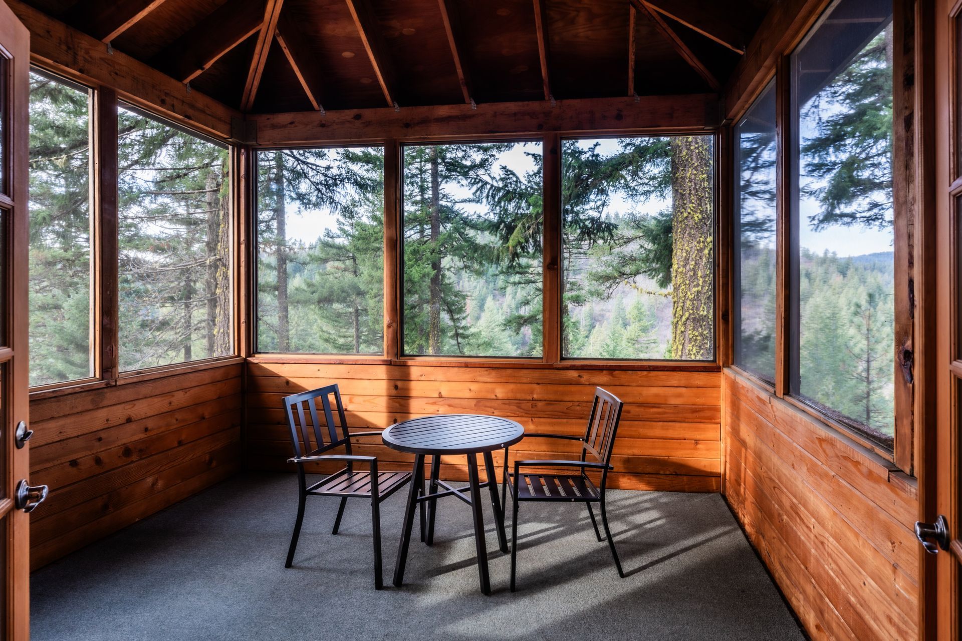 A screened in porch with a table and chairs