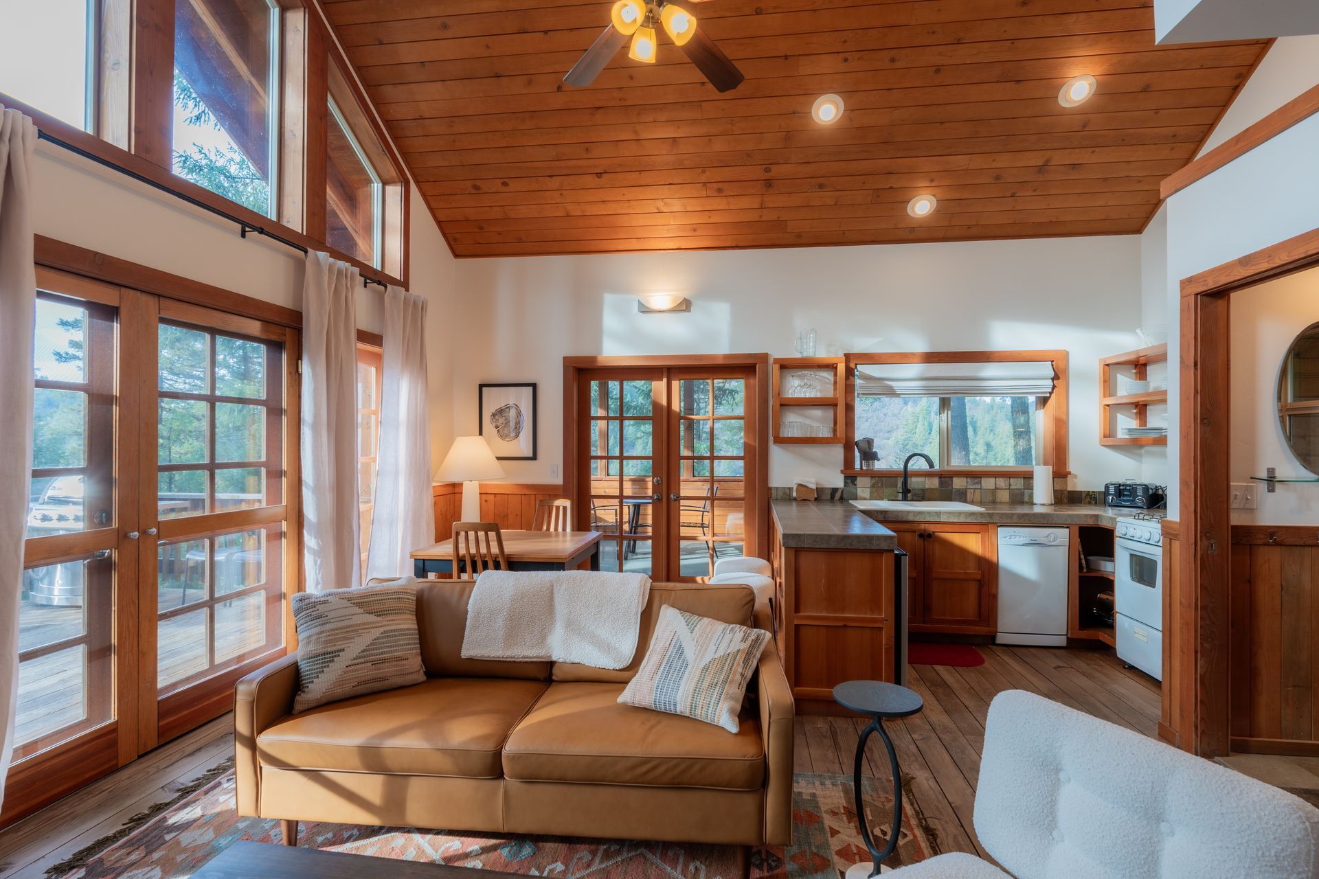 A living room with a couch , chairs , and a ceiling fan.