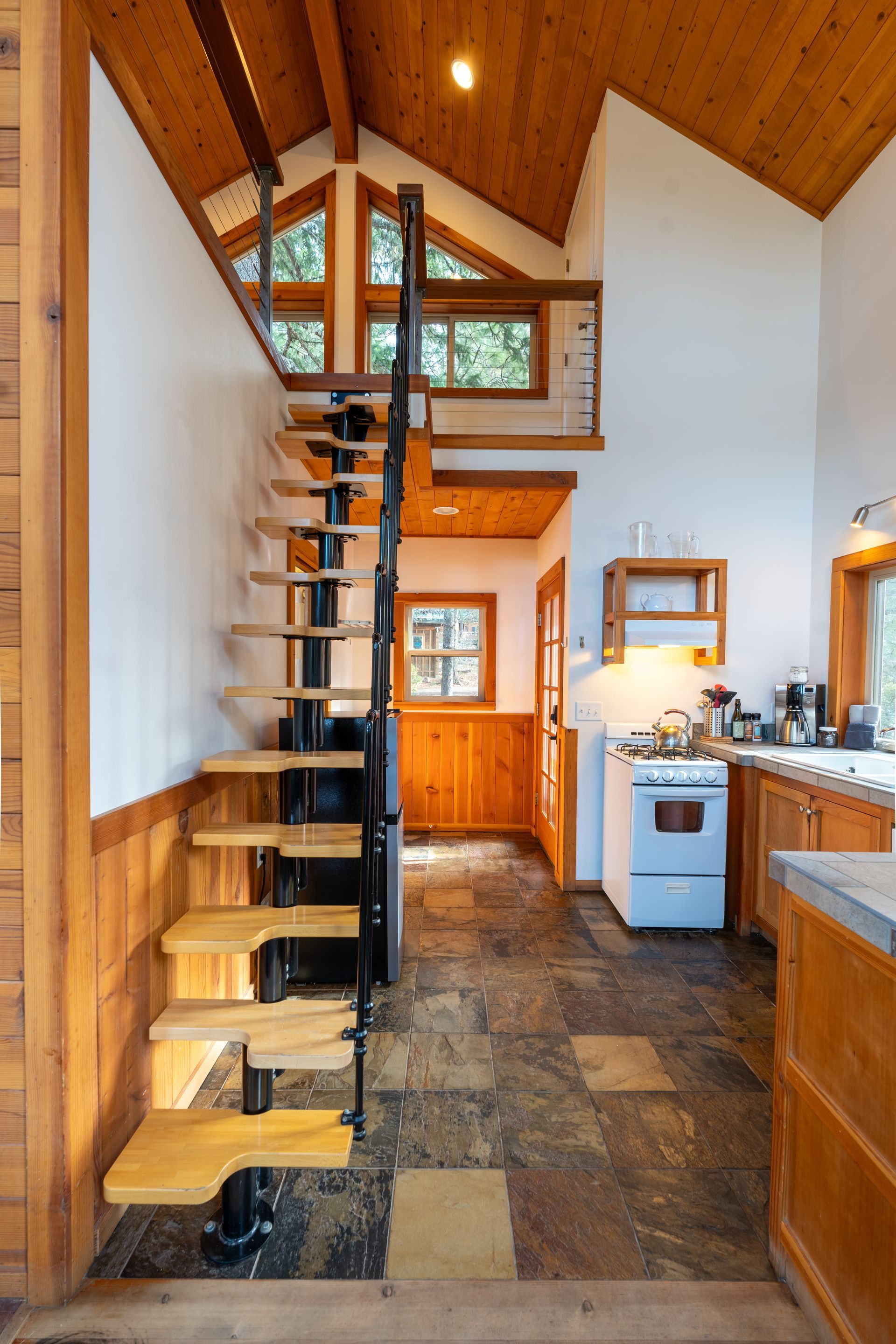 A kitchen with a spiral staircase leading to the second floor