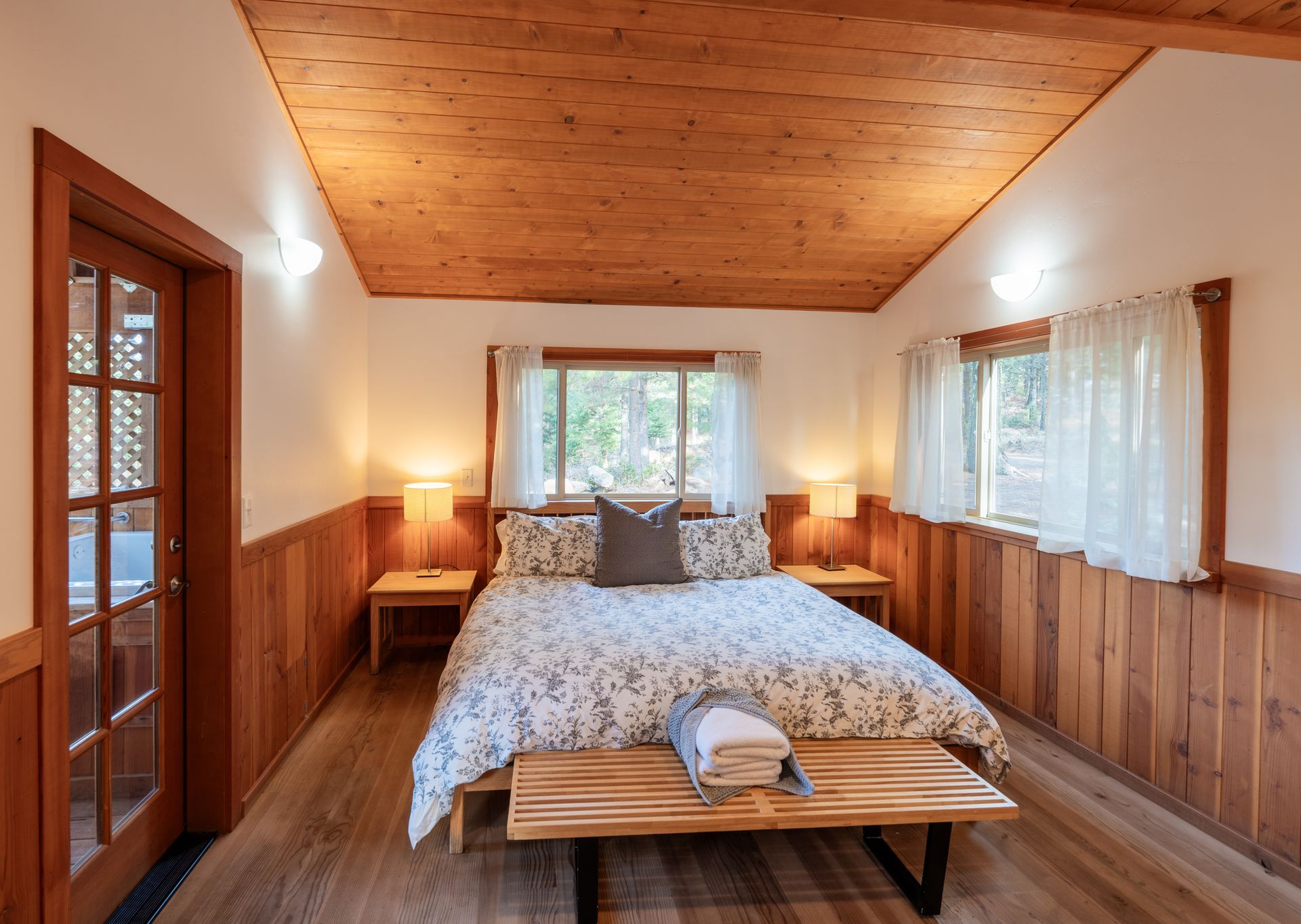 A bedroom with a king size bed and a wooden bench.