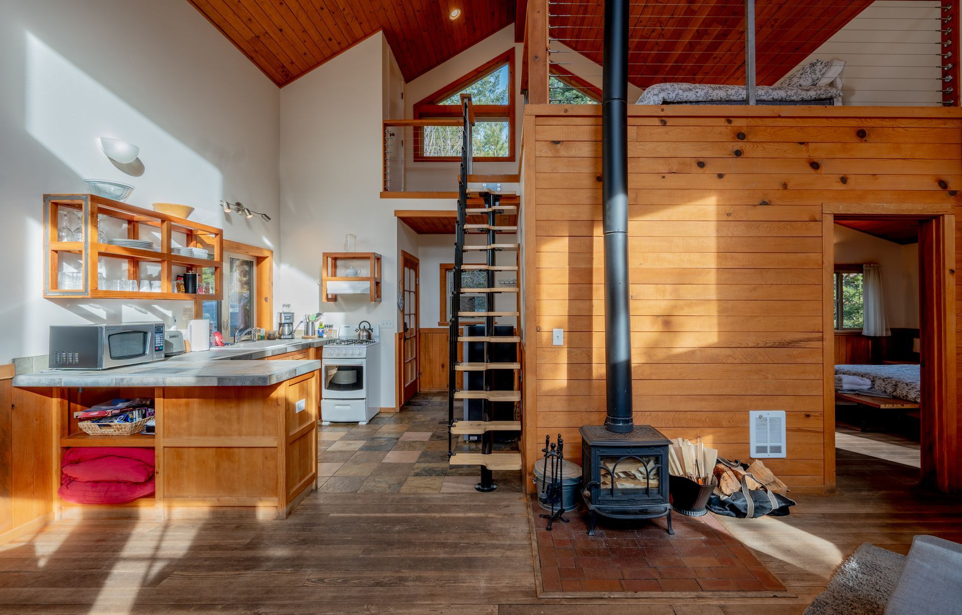 A wooden house with a spiral staircase leading to the second floor.