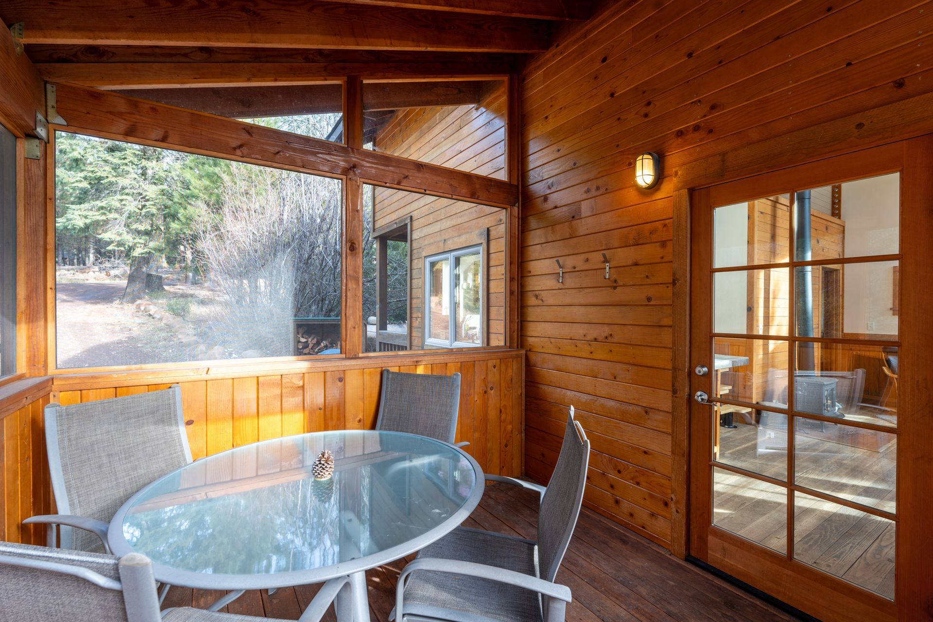 A screened in porch with a glass table and chairs