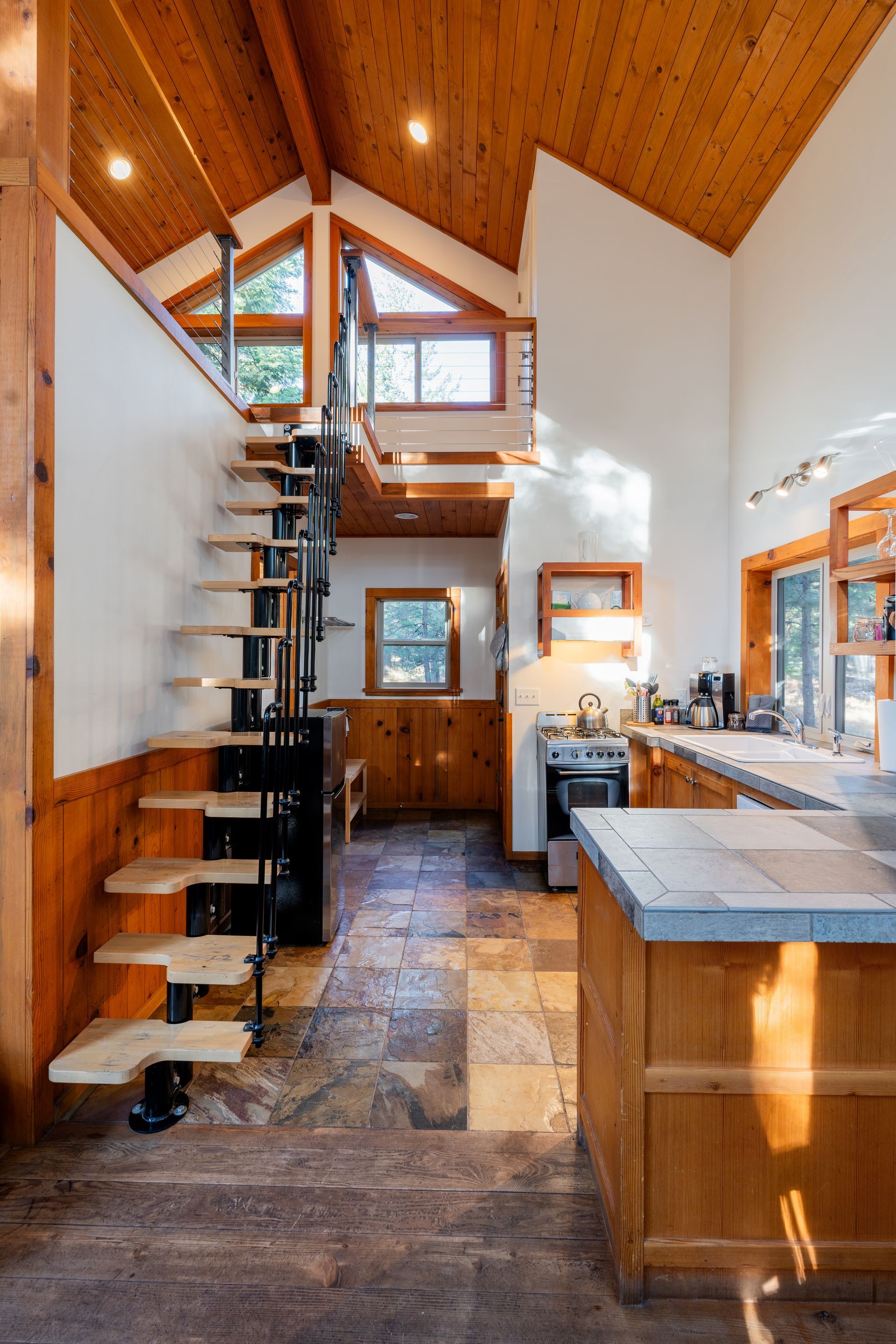 A kitchen with a spiral staircase leading to the second floor.