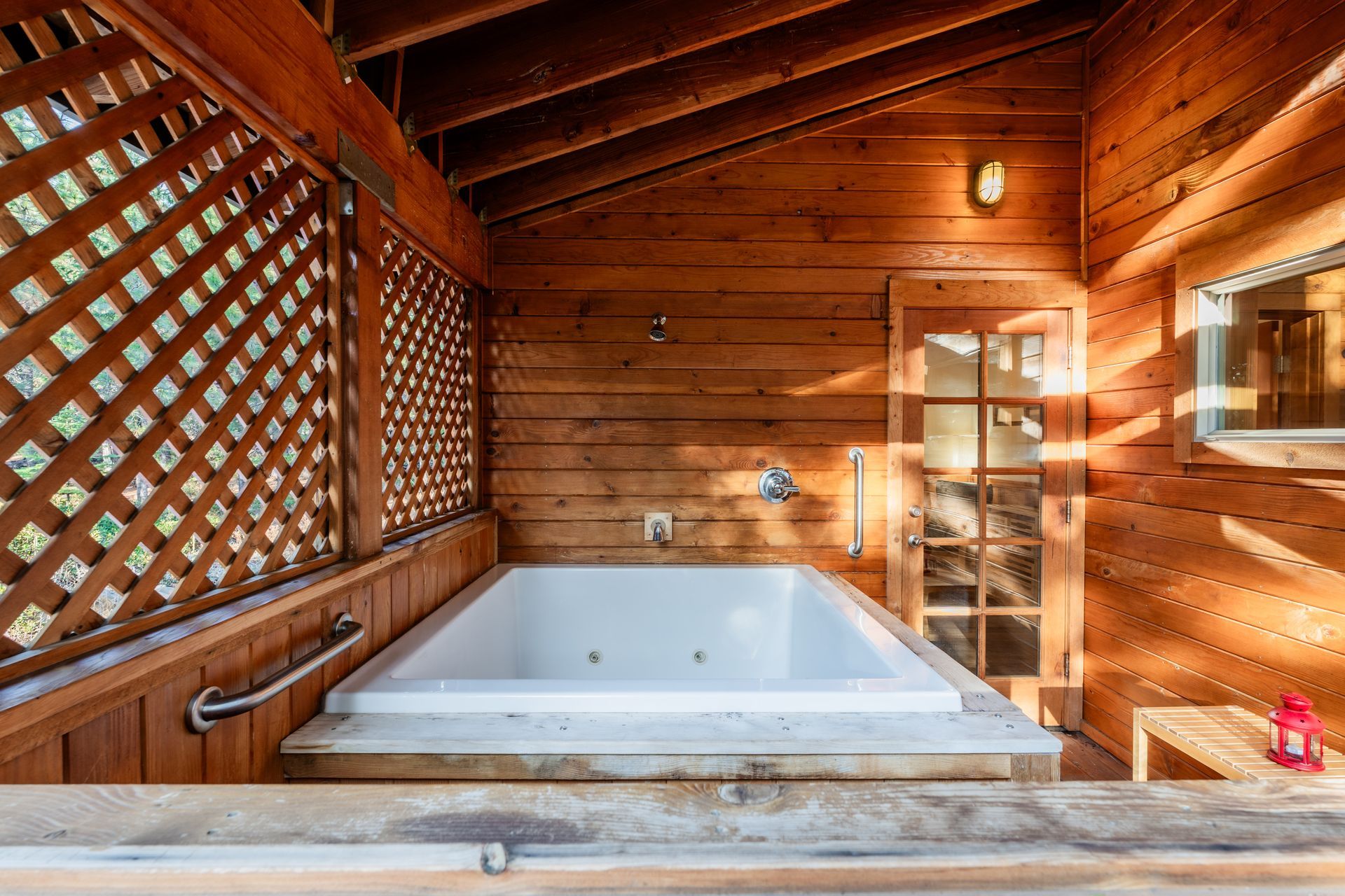 There is a jacuzzi tub in the middle of a wooden cabin.