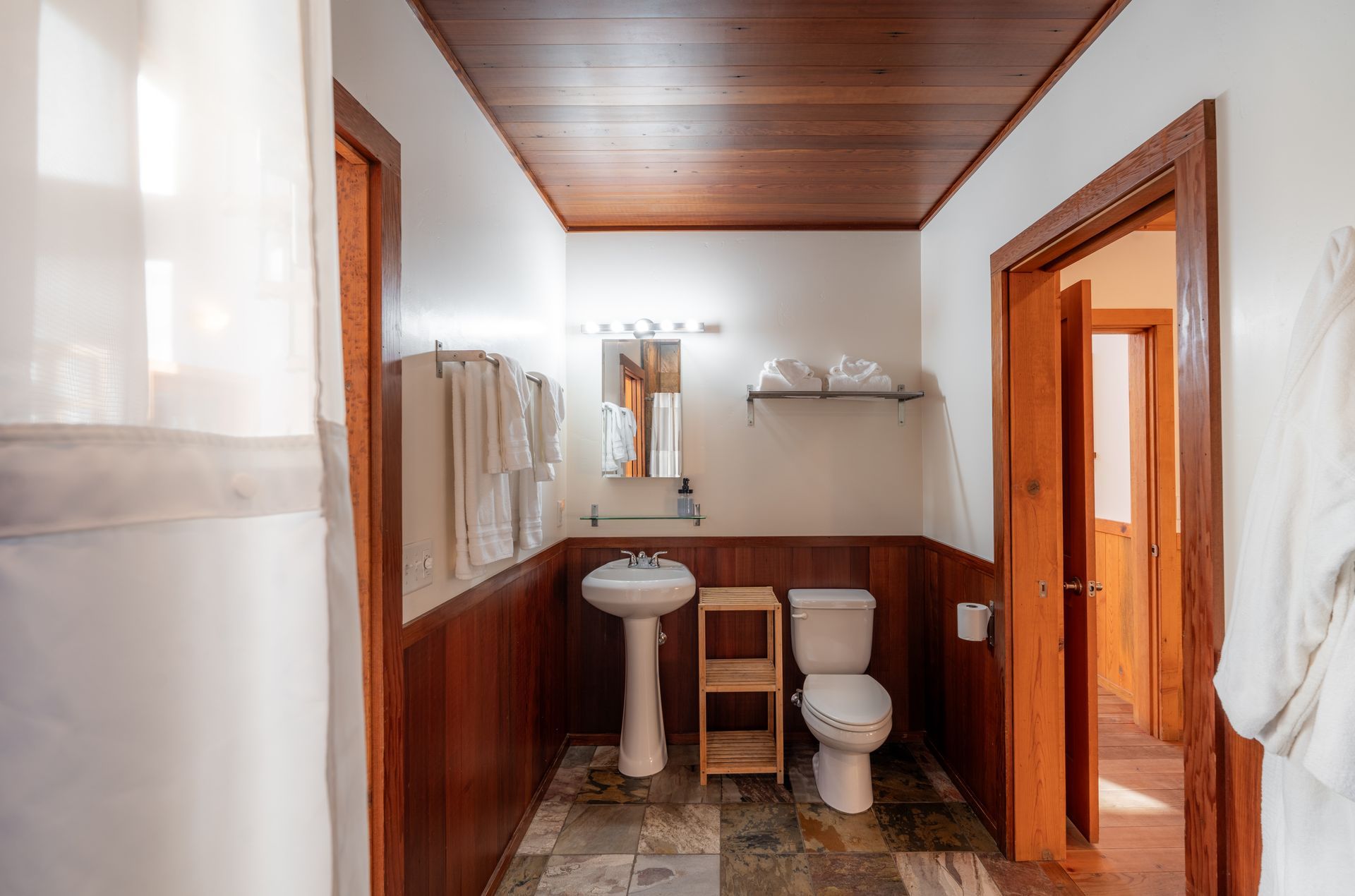 A bathroom with a sink , toilet and mirror.