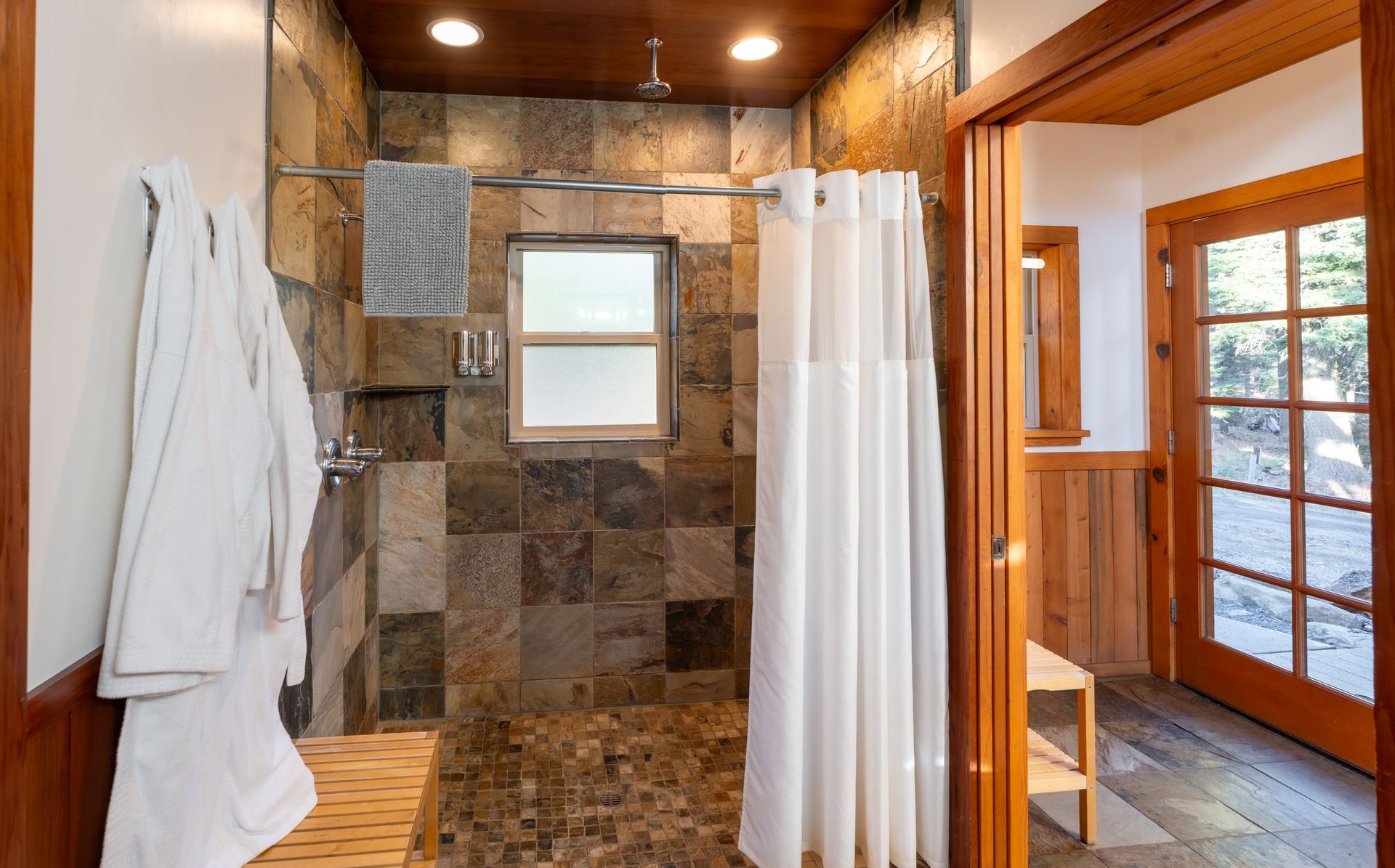 A bathroom with a walk in shower and a window.