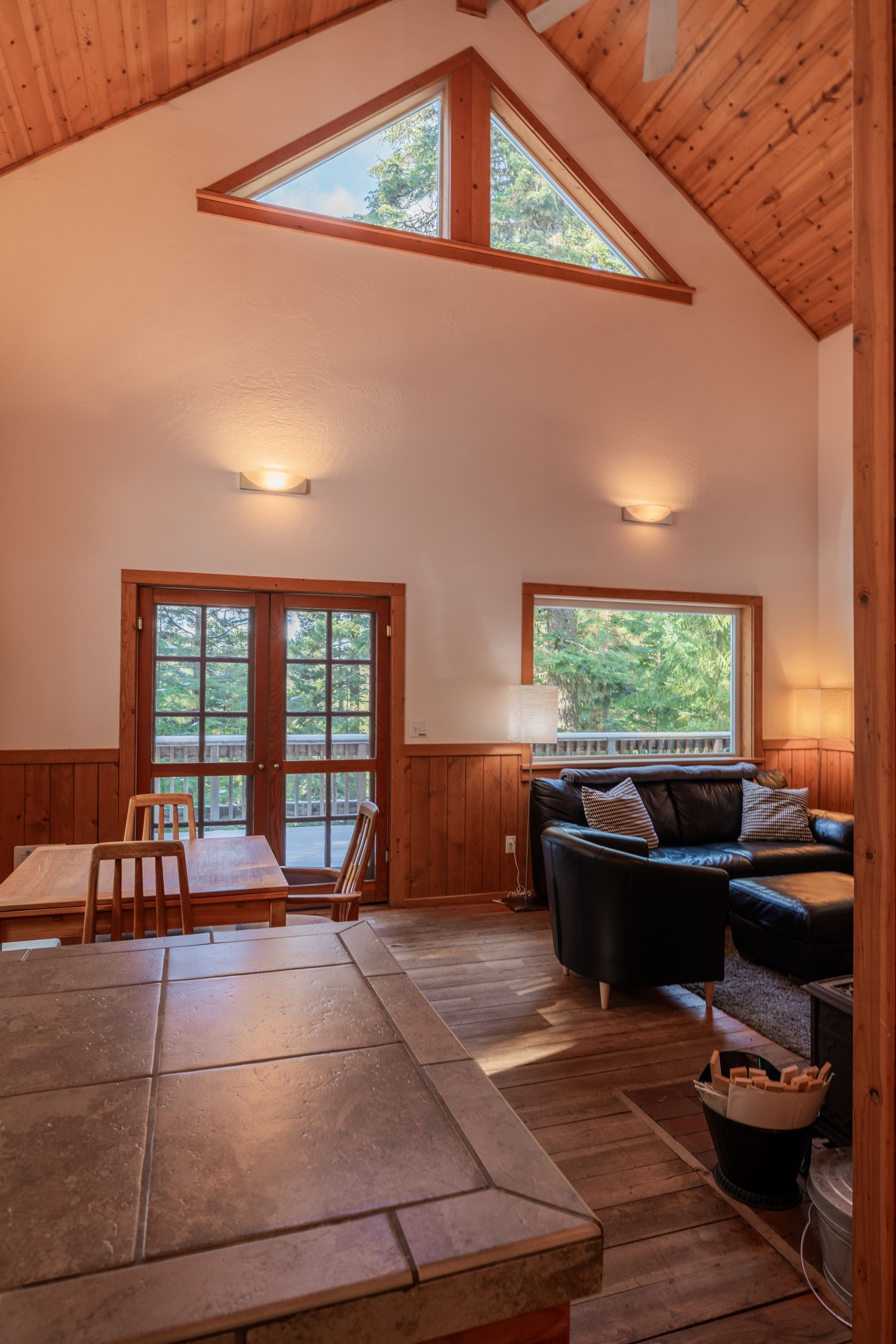 A living room with a vaulted ceiling and a couch and chairs