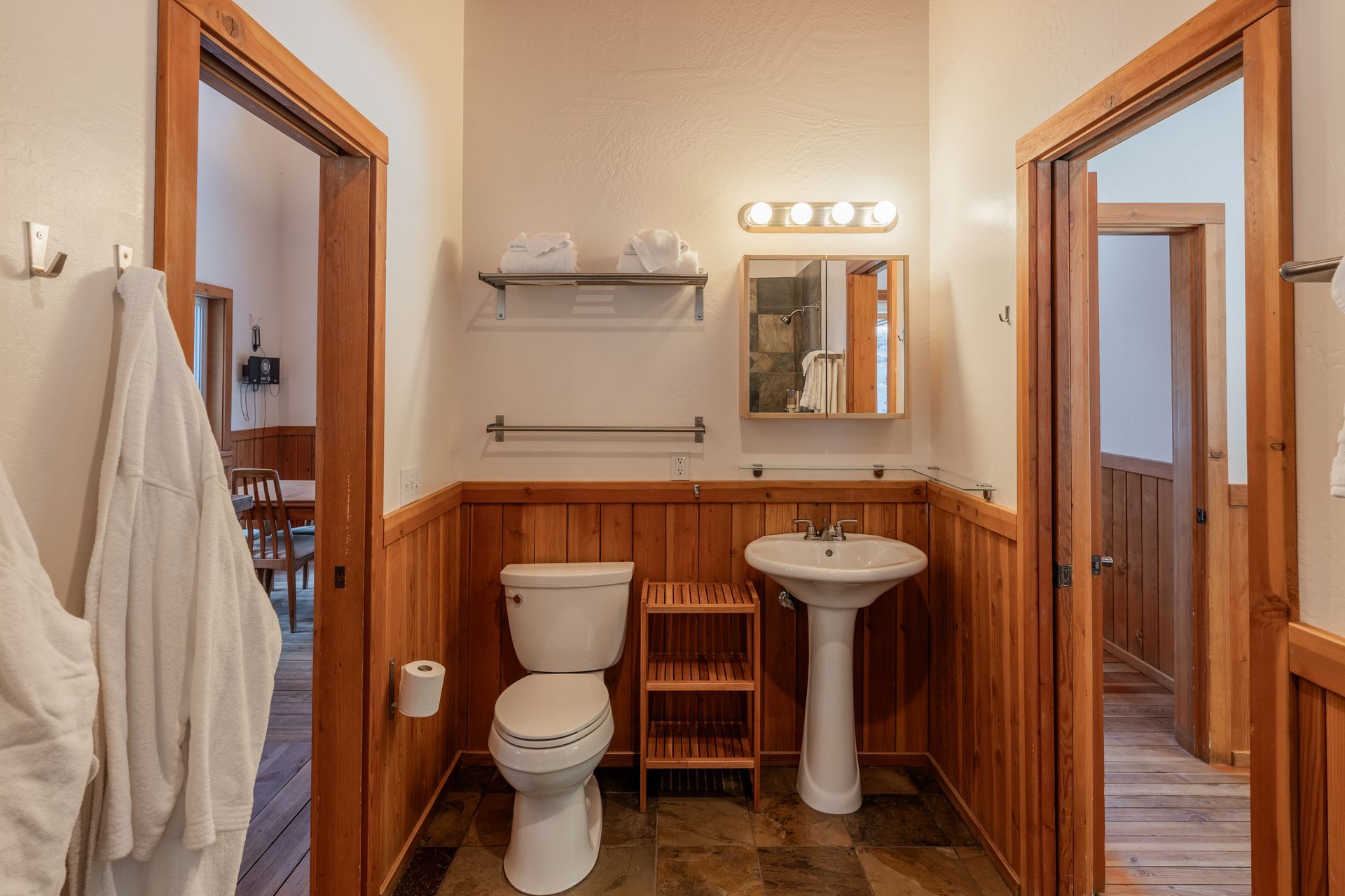 A bathroom with a toilet , sink and mirror.