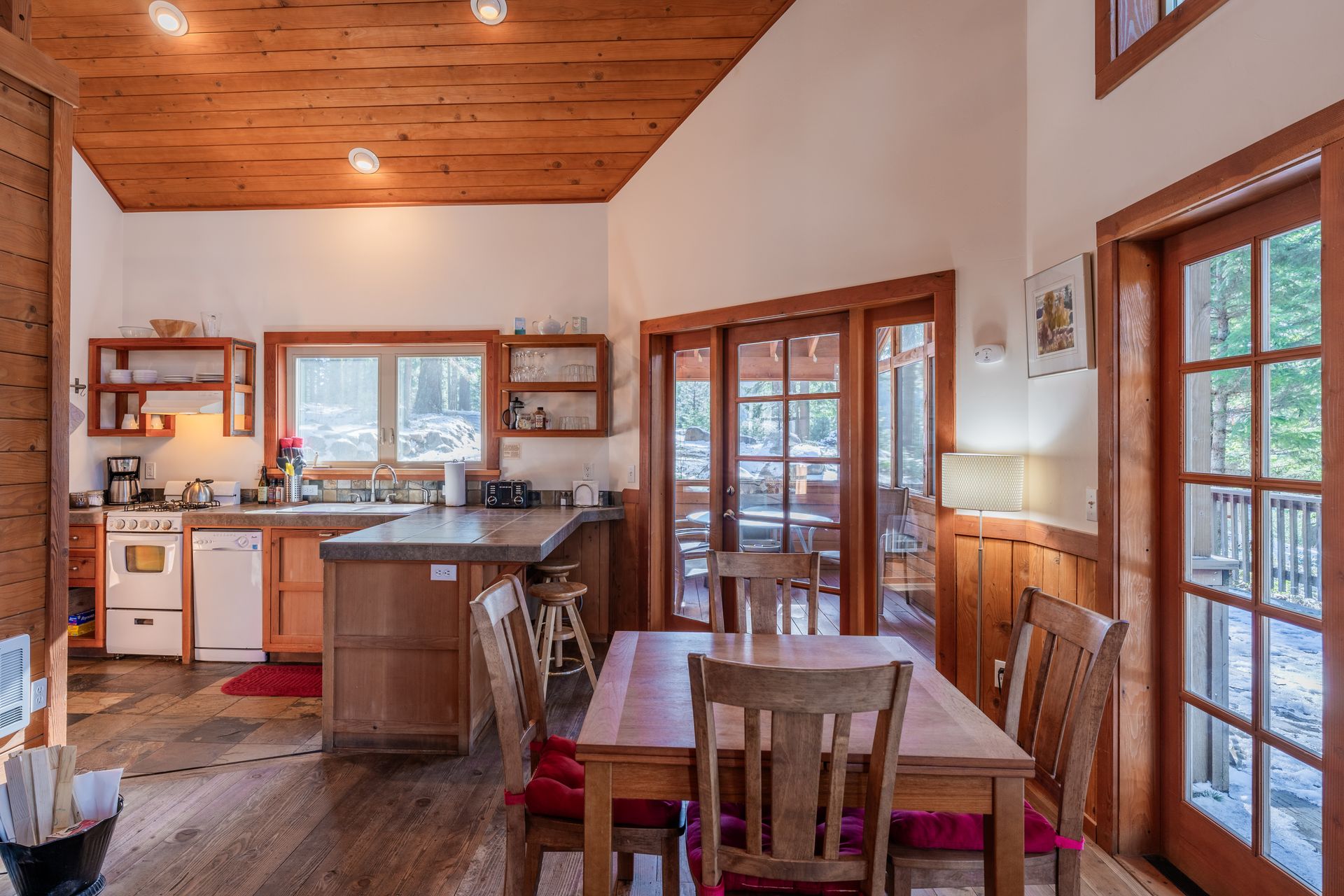 A kitchen and dining room in a cabin with a table and chairs.