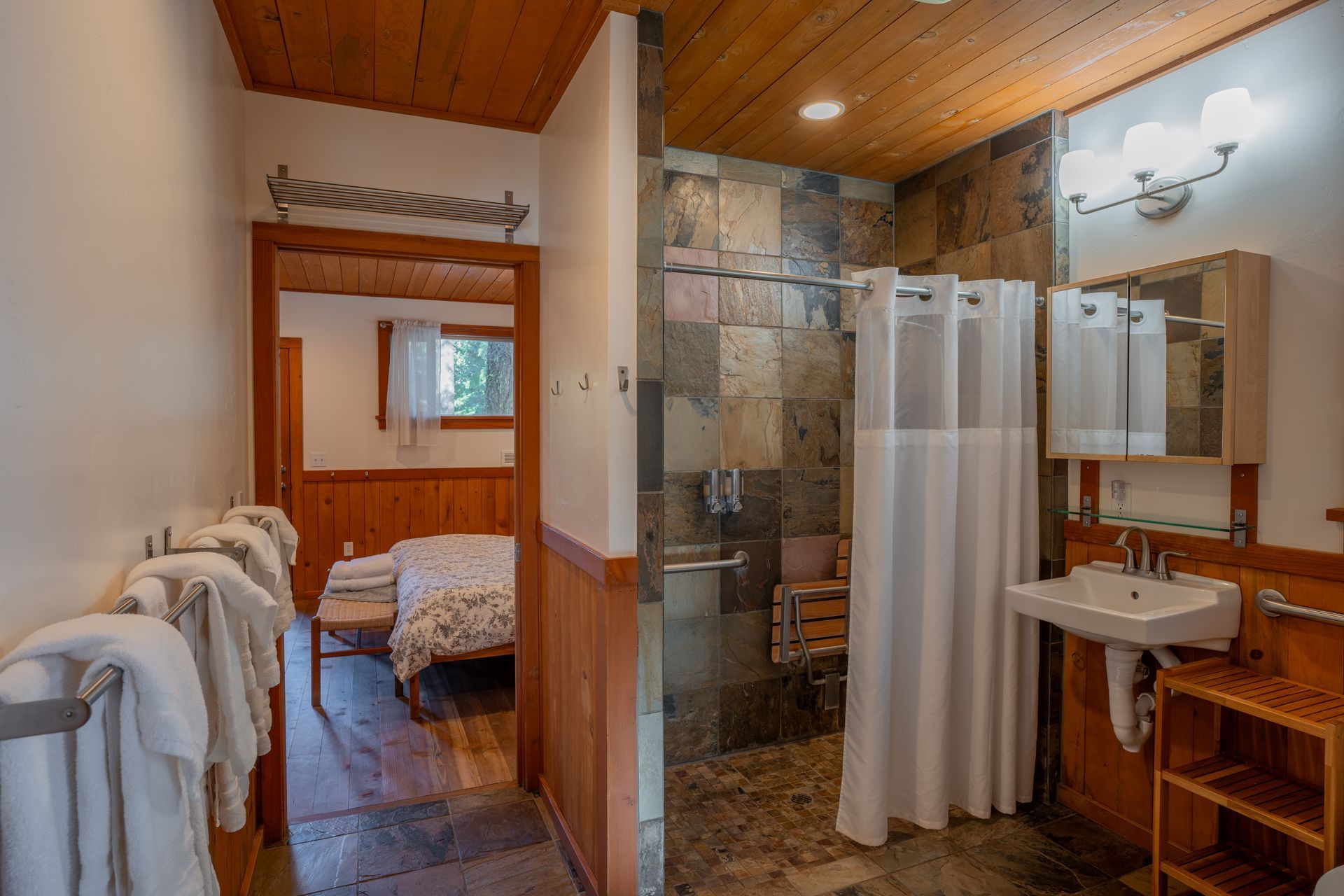 A bathroom with a walk in shower , sink and mirror.