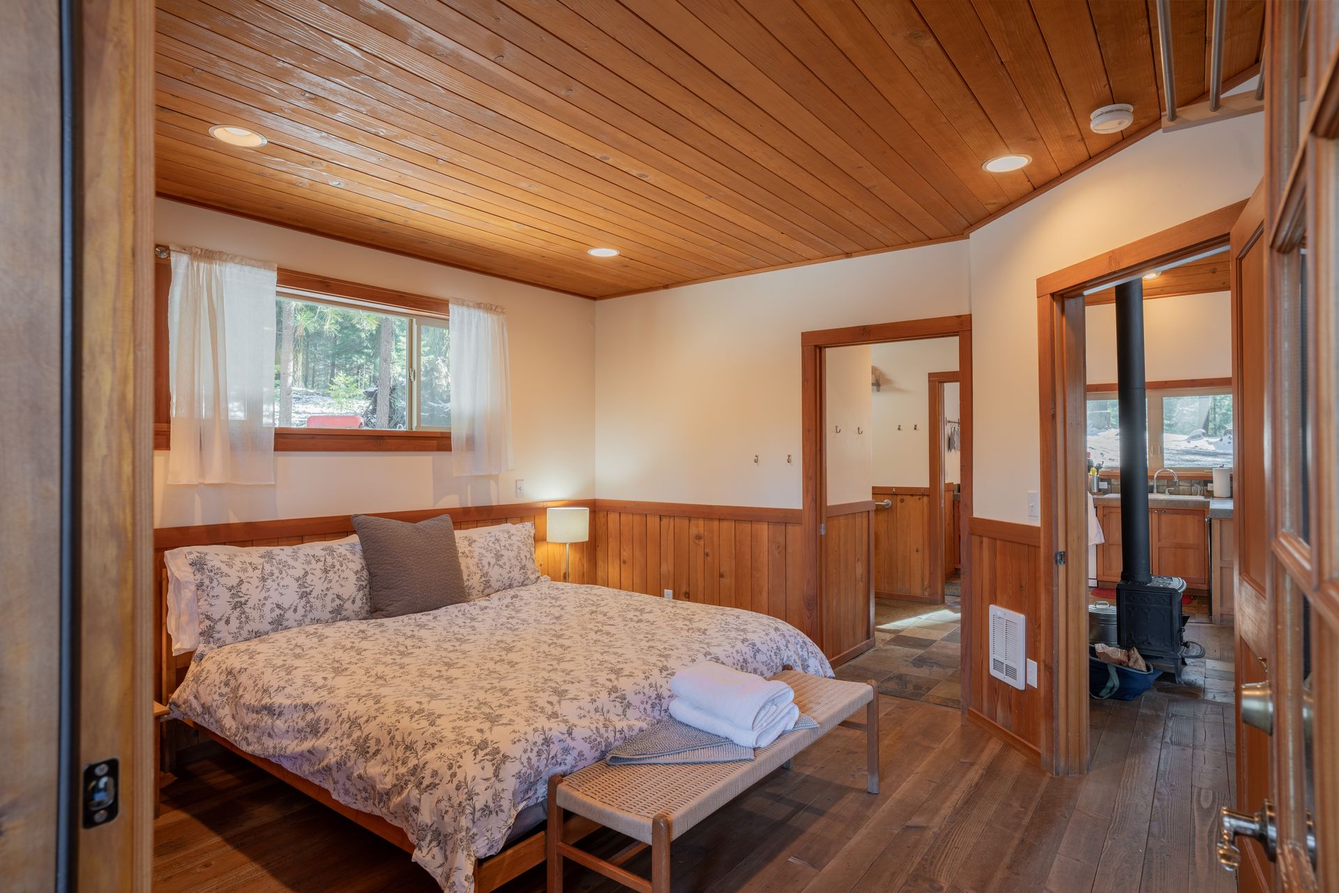 A bedroom with a bed and a bench in it.