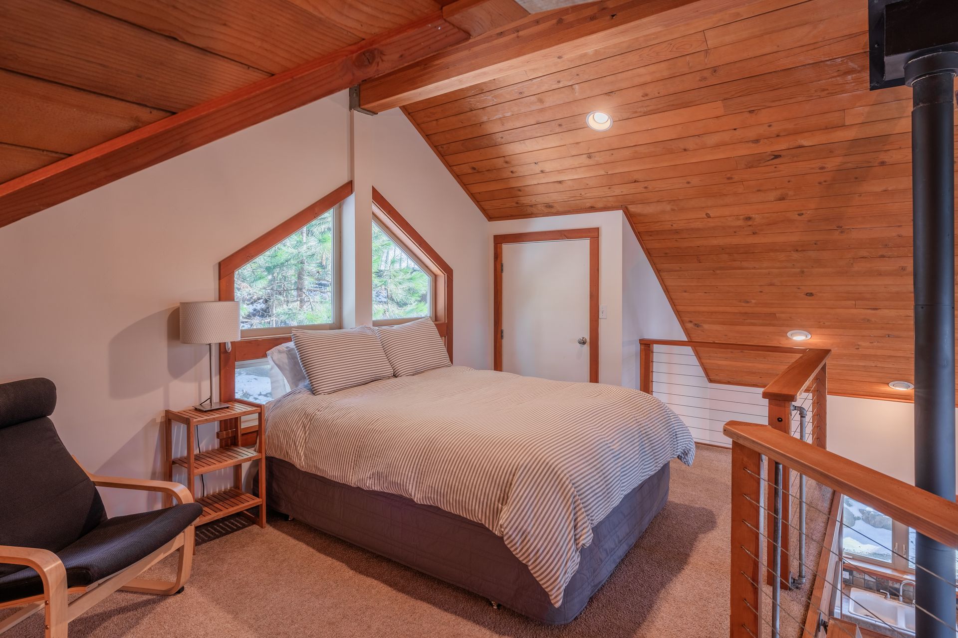A bedroom with a king size bed and a chair.
