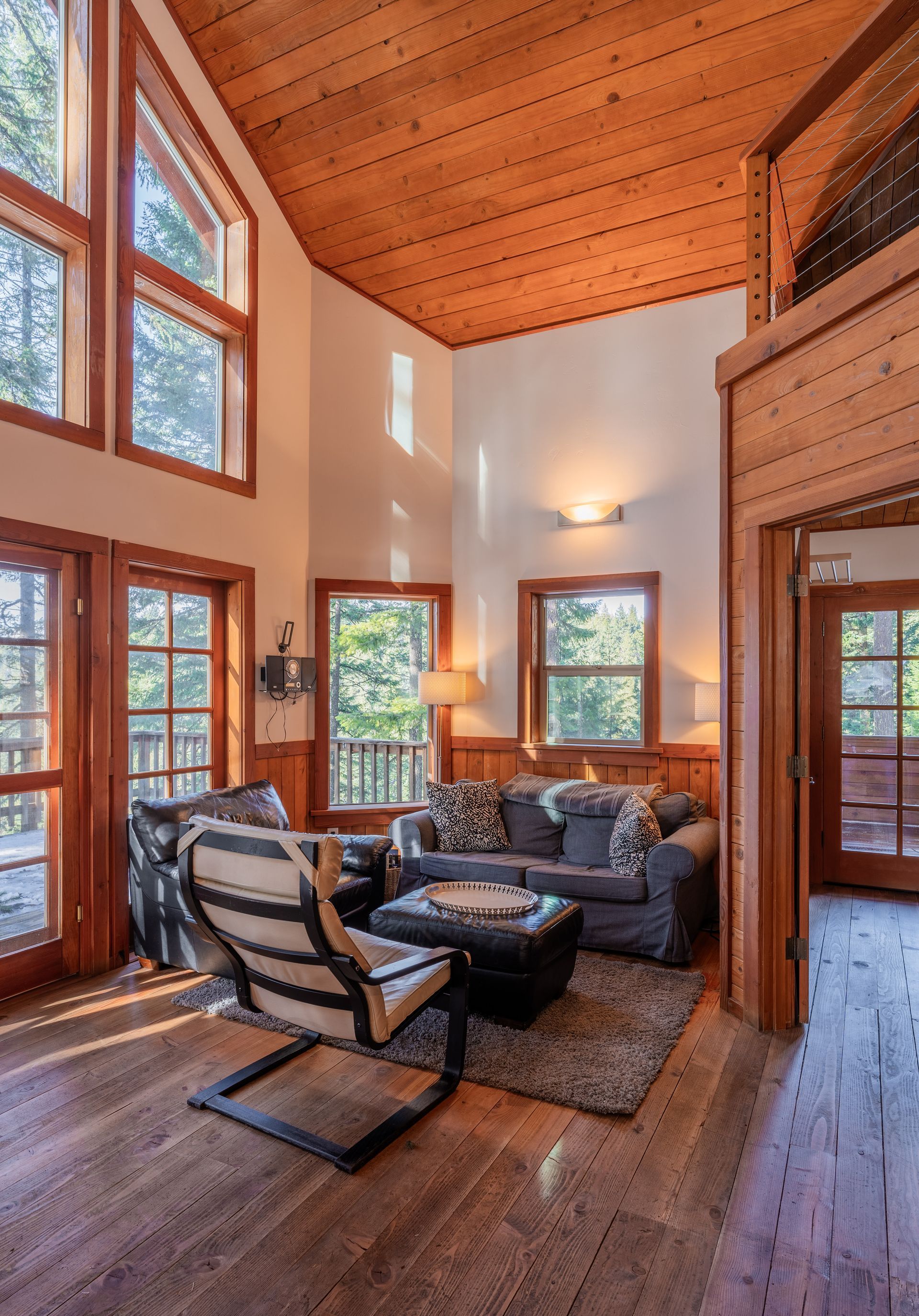 A living room with a vaulted ceiling and lots of windows